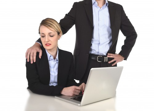 young attractive businesswoman suffering sexual harassment and abuse of colleague or office boss touching her at work with excessive familiarity in work relationship concept